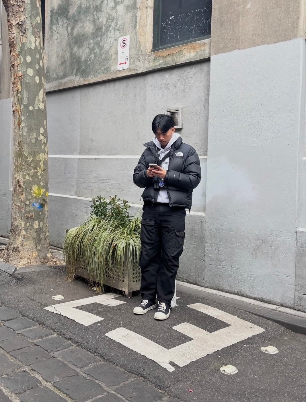 Leo standing on a Melbourne street with his Fujifilm X100V around his neck